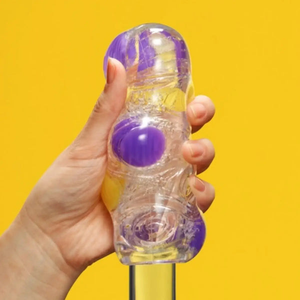 Hand holding TENGA BOBBLE MAGIC MARBLES with clear bottle and colorful magic marbles