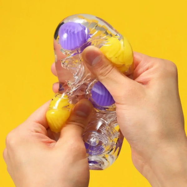 Clear squeezable TENGA BOBBLE MAGIC MARBLES fidget toy with purple and yellow marbles