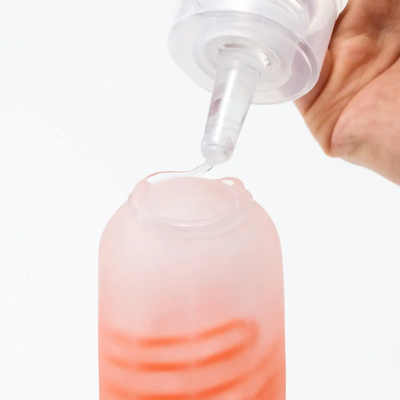 TENGA LOTION MILD sex toy lubricant with easy dispenser pouring into pink container