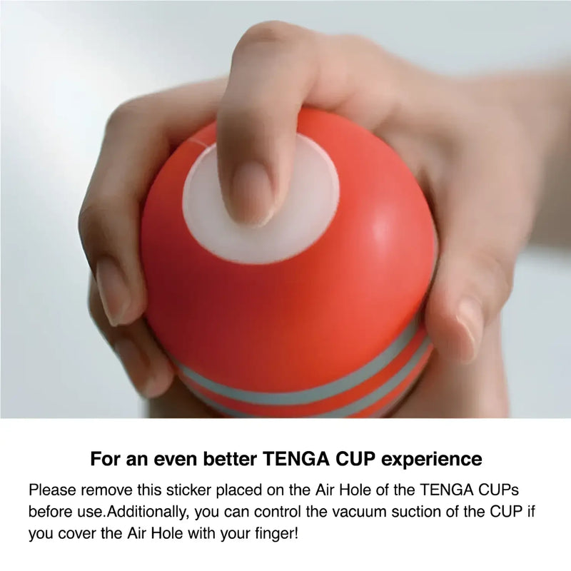 Red TENGA ROLLING HEAD CUP with white opening and grey stripes in hand
